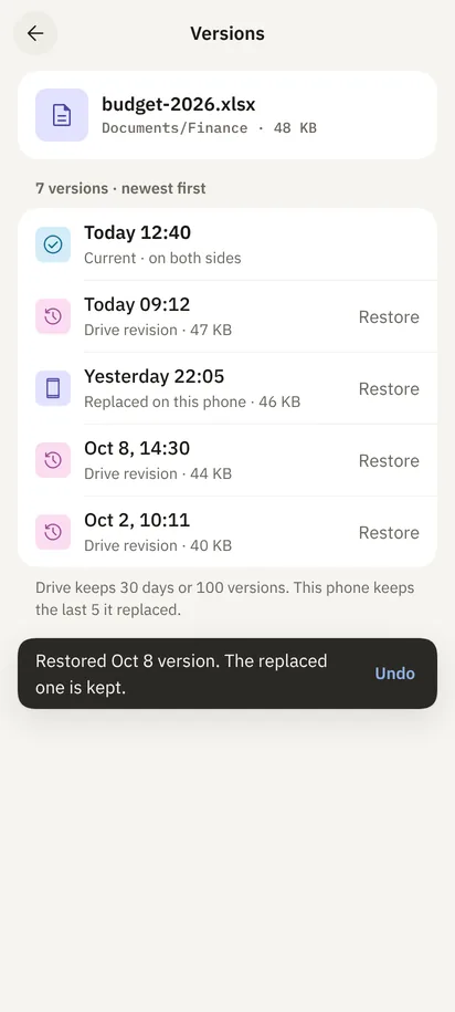 Version history for budget-2026.xlsx: seven versions, each with Restore